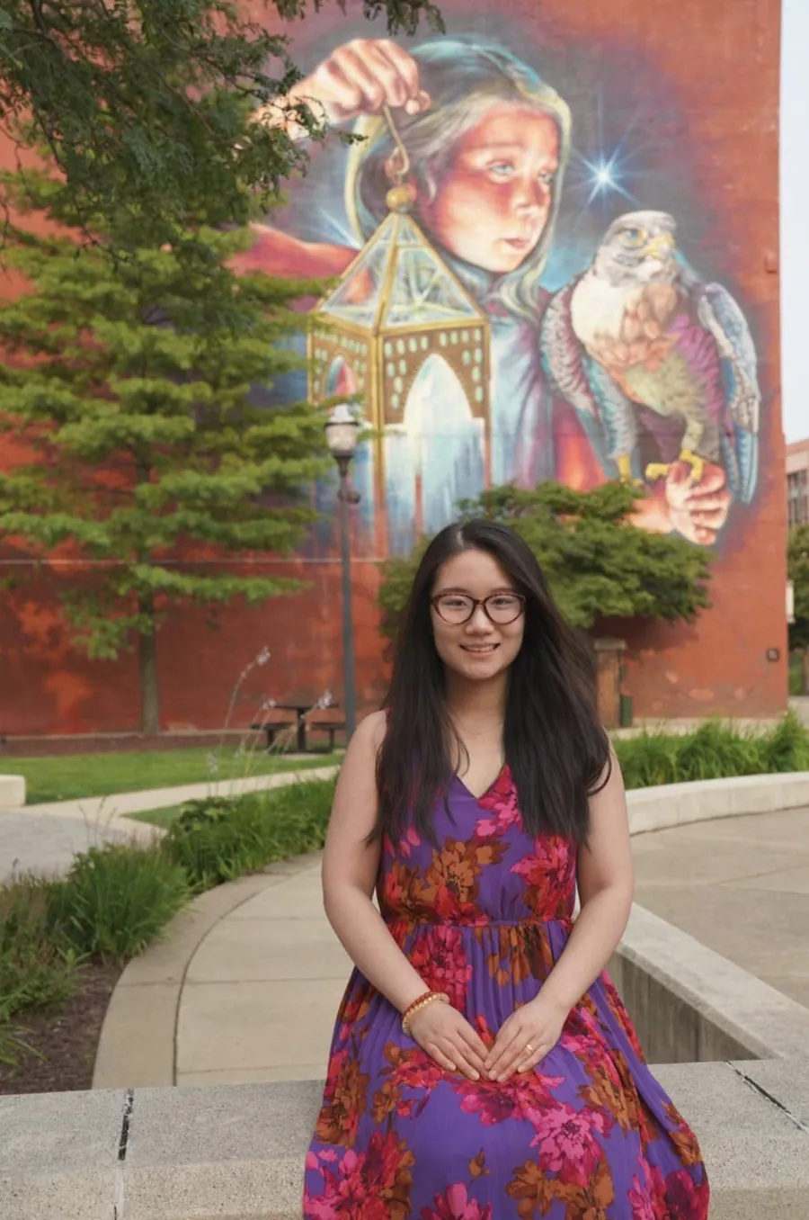 Greenie Gai in front of a mural in Ann Arbor