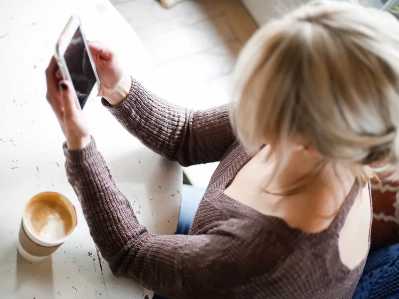A woman reading her phone over coffee