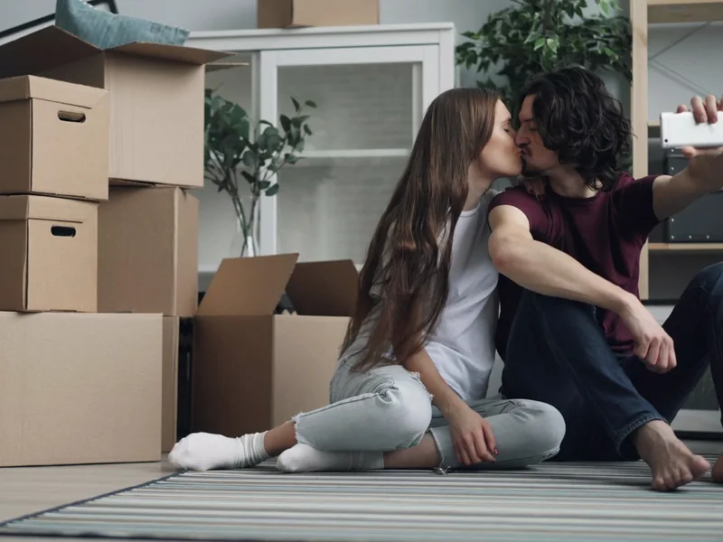 A couple taking a celebratory selfie among boxes