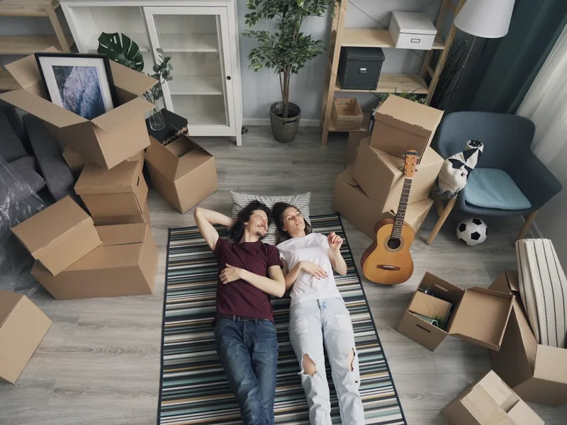 A couple lying on the floor among packed boxes